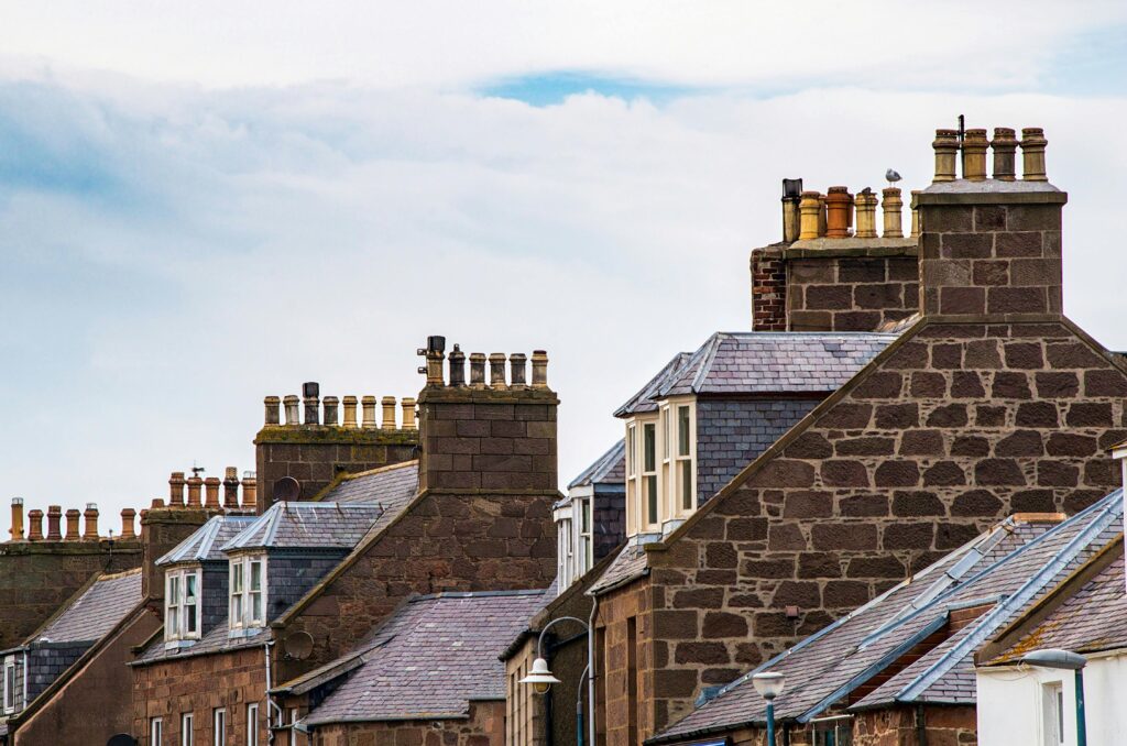 A picturesque view of old town rooftops showcasing traditional architecture and chimneys.